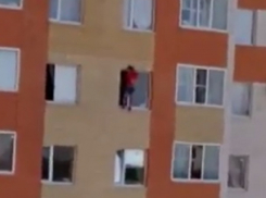 На грани смерти находится неизвестный молодой человек, свисающий из окна дома в Ставрополе