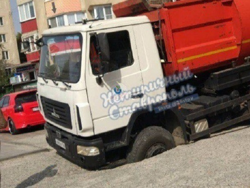 Мусоровоз застрял в огромной дыре на дороге в Ставрополе 